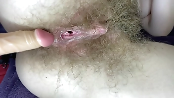Hairy girl fucks her wet big clit pussy with dildo in close up